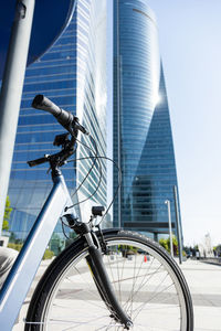 Contemporary blue bike parked on paved street in city center on sunny day