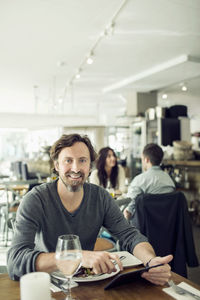 Portrait of a young man sitting in restaurant