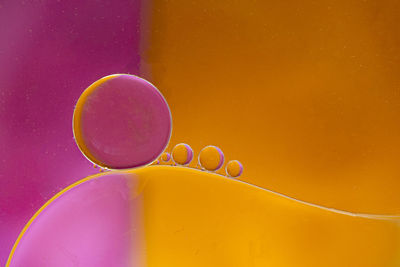 Close-up of bubbles against yellow background