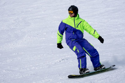 Full length of man skiing on snow covered field