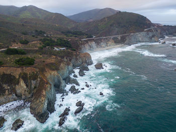 Scenic view of sea and mountains against sky