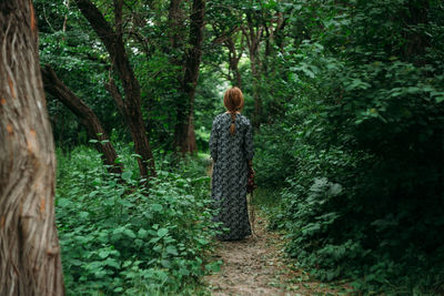 Rear view of child walking in forest