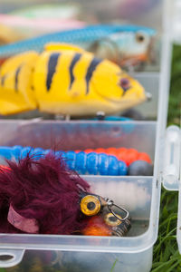 Close-up of multi colored fishing hooks in box