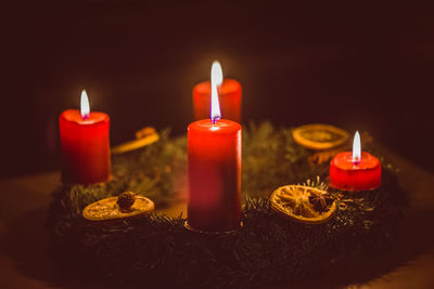 Close-up of lit candles in darkroom