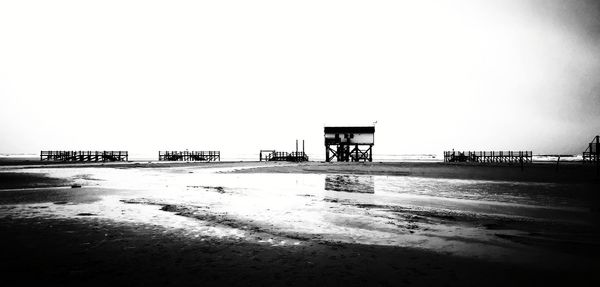 Scenic view of beach against clear sky during winter