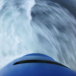 Low angle view of airplane flying over sea against blue sky