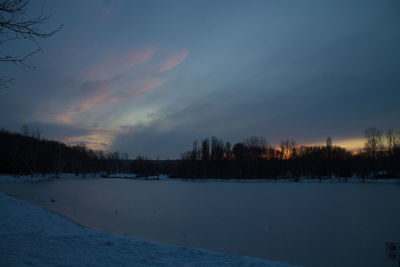 Scenic view of frozen landscape against sky during winter