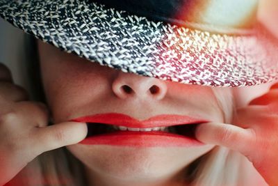 Close-up of woman stretching mouth