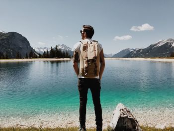 Man standing by lake against sky