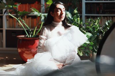 Young woman wearing mask against plants