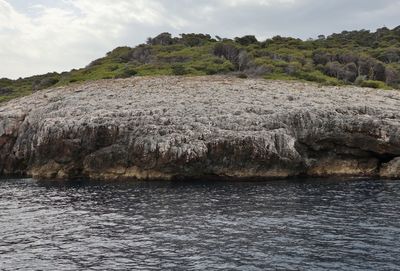 Scenic view of rocks in sea against sky