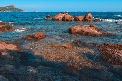 Rock formations on sea shore against sky