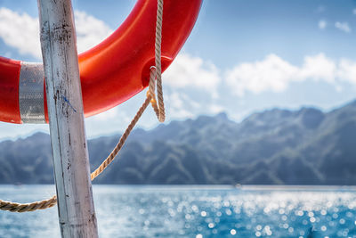 Close-up of red flags hanging against lake