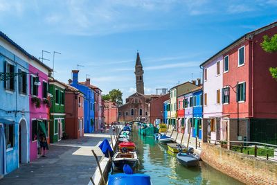 Boats in canal with san martino in background at burano