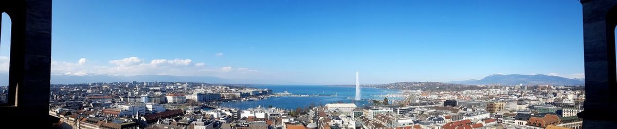 High angle view of city by sea and buildings against sky