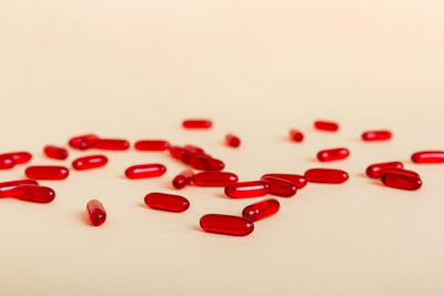 Close-up of pills spilling from bottle against pink background