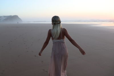 Rear view of woman standing on beach