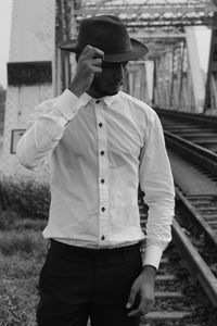 Full length of man standing by railroad tracks