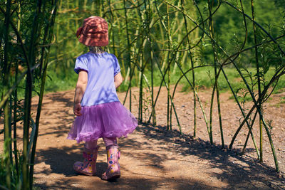 Full length rear view of girl walking on footpath