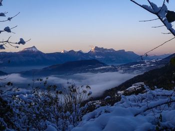 Scenic view of snowcapped mountains against sky during sunset