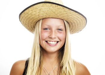 Portrait of smiling girl wearing straw hat, studio shot