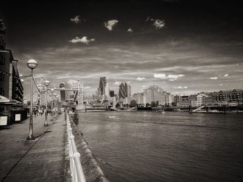 Scenic view of river by city against sky