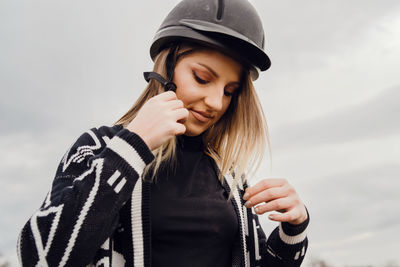 Young woman looking away against sky