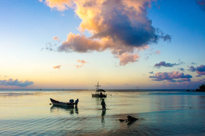 Silhouette boats in sea against sky during sunset