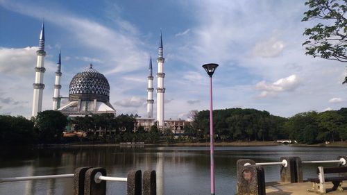 Temple by lake against sky