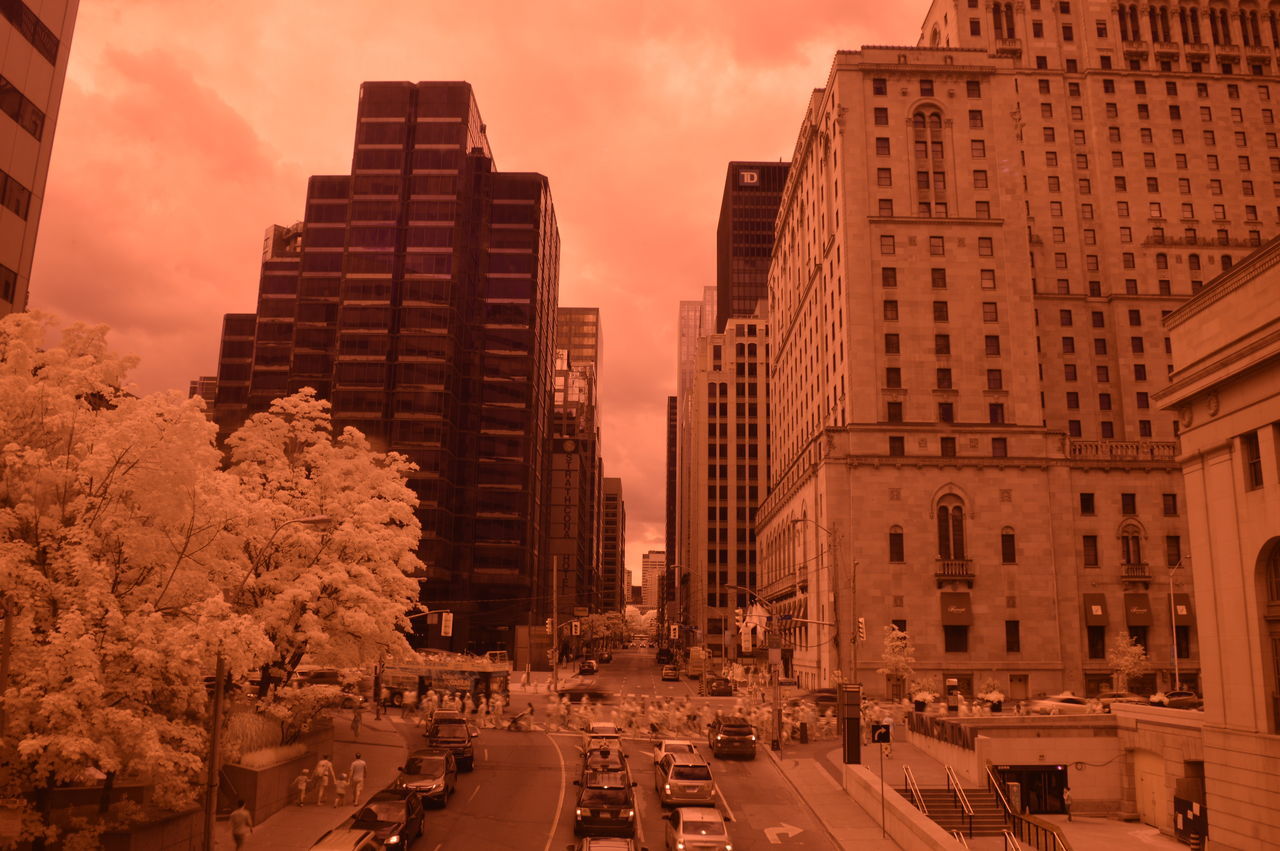 architecture, building exterior, built structure, land vehicle, city, mode of transport, sky, road, traffic, city life, city street, building, the way forward, cloud - sky, outdoors, tall - high, diminishing perspective, travel destinations, modern, no people, vanishing point, cloud, parking, day