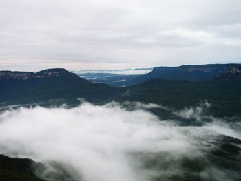 Scenic view of mountains against cloudy sky