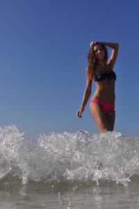 Young woman in sea against clear sky