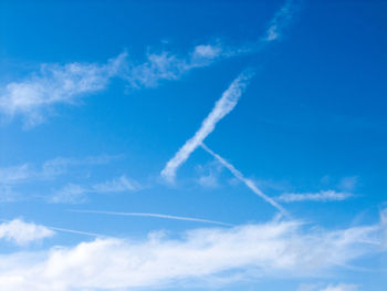 Low angle view of vapor trail against blue sky