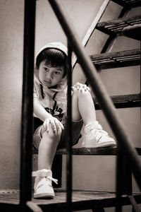 Portrait of girl sitting on ladder