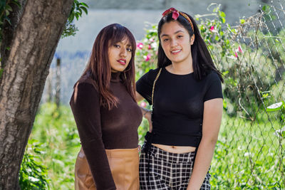 Beautiful latin girls smiling and walking in the city park, garden with many plants