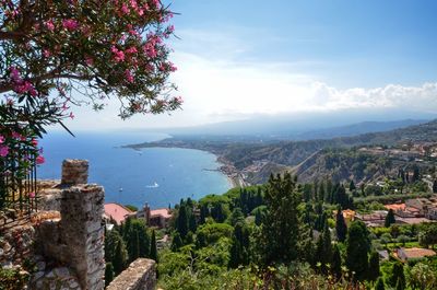 Scenic view of townscape by sea against sky