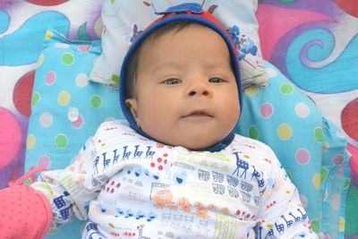 Portrait of cute baby lying on bed