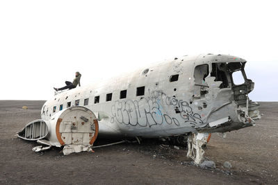 Abandoned airplane on airport runway against sky