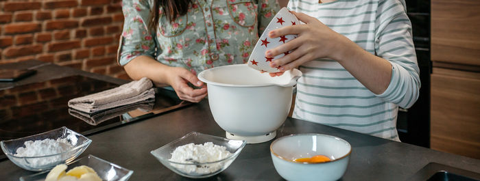 Midsection of woman using mobile phone on table