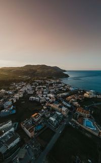 High angle view of townscape by sea against sky