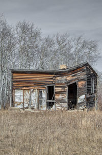 Abandoned house on field against sky