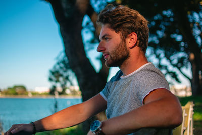 Side view of young man looking away outdoors