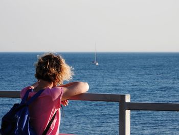 Rear view of woman looking at sea against sky