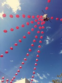 Low angle view of multi colored balloons against sky