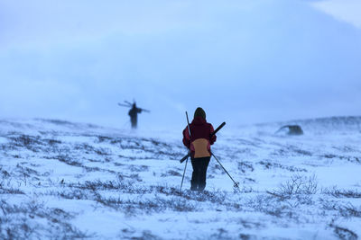 People skiing, rear view