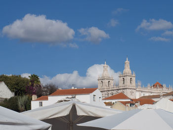 Two bell towers of a church on rooftops and awnings