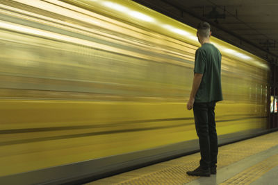 Rear view of man walking on railroad station