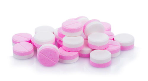 Close-up of pills over white background