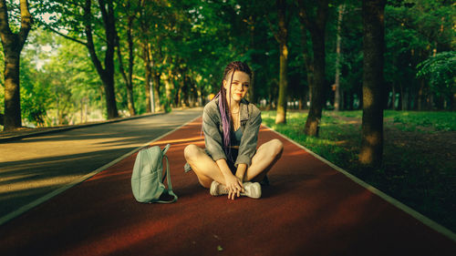 Portrait of young woman sitting in park