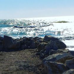 Surface level of rocks on beach against sky